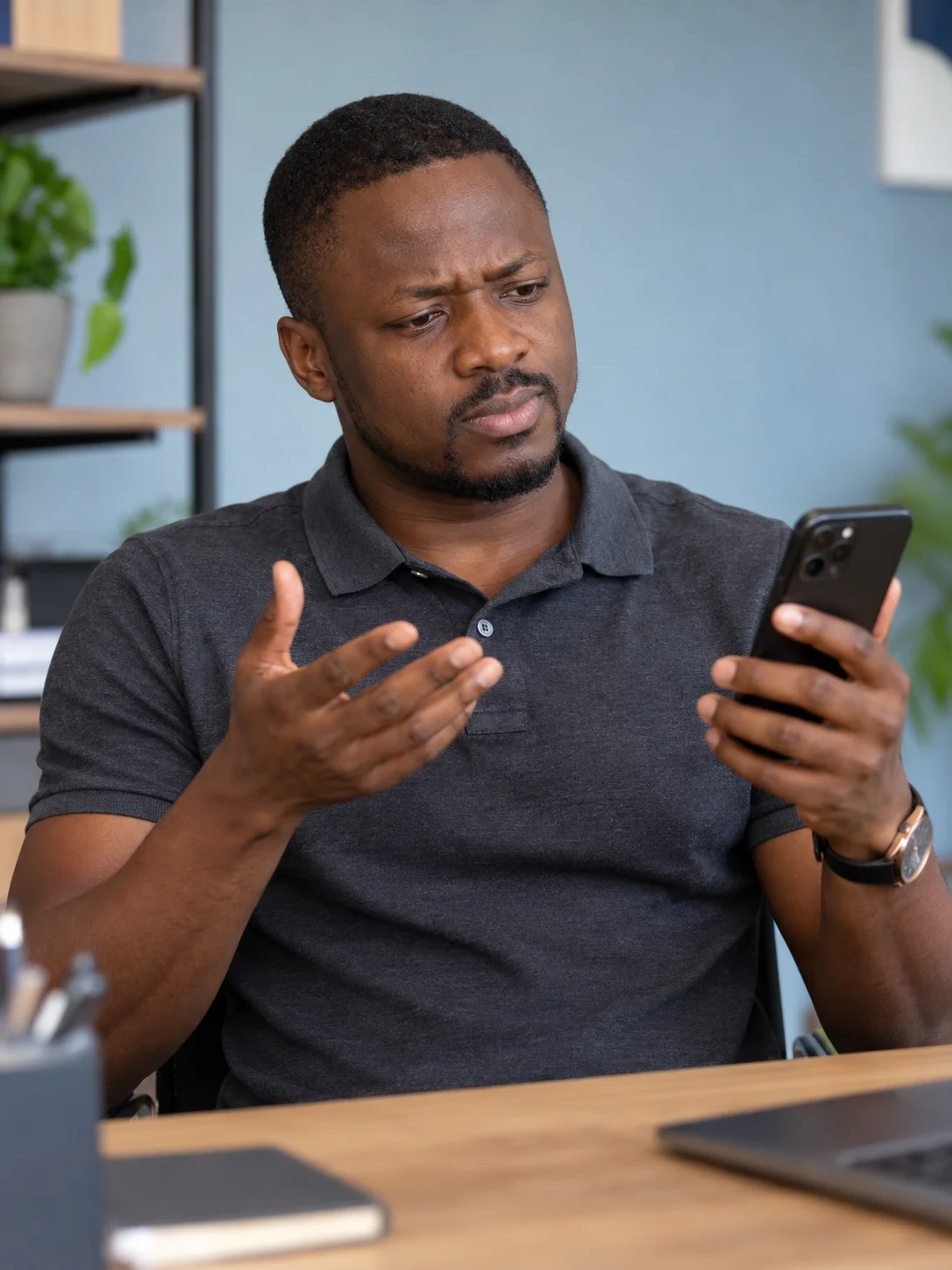 Entrepreneur en polo gris regardant son téléphone